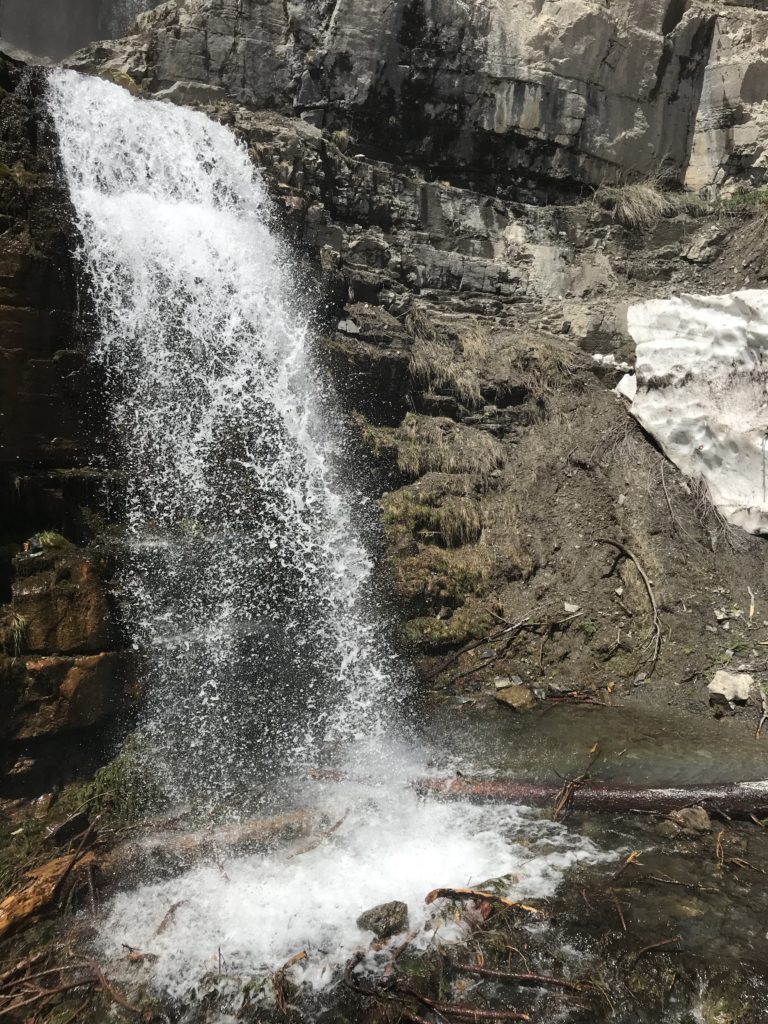 tall waterfall on brown cliff
